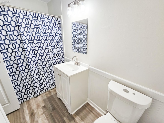 bathroom with hardwood / wood-style floors, vanity, and toilet