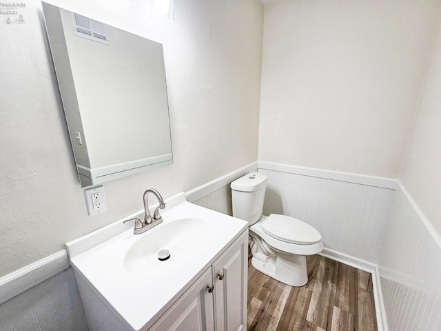 bathroom with vanity, toilet, and wood-type flooring