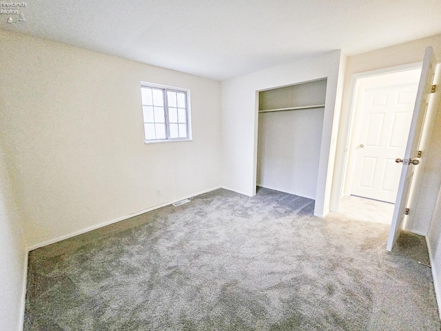 unfurnished bedroom featuring carpet floors and a closet