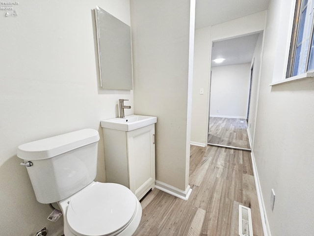 bathroom featuring vanity, toilet, and wood-type flooring