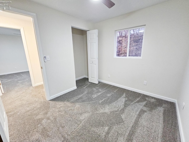 unfurnished bedroom with dark carpet and ceiling fan