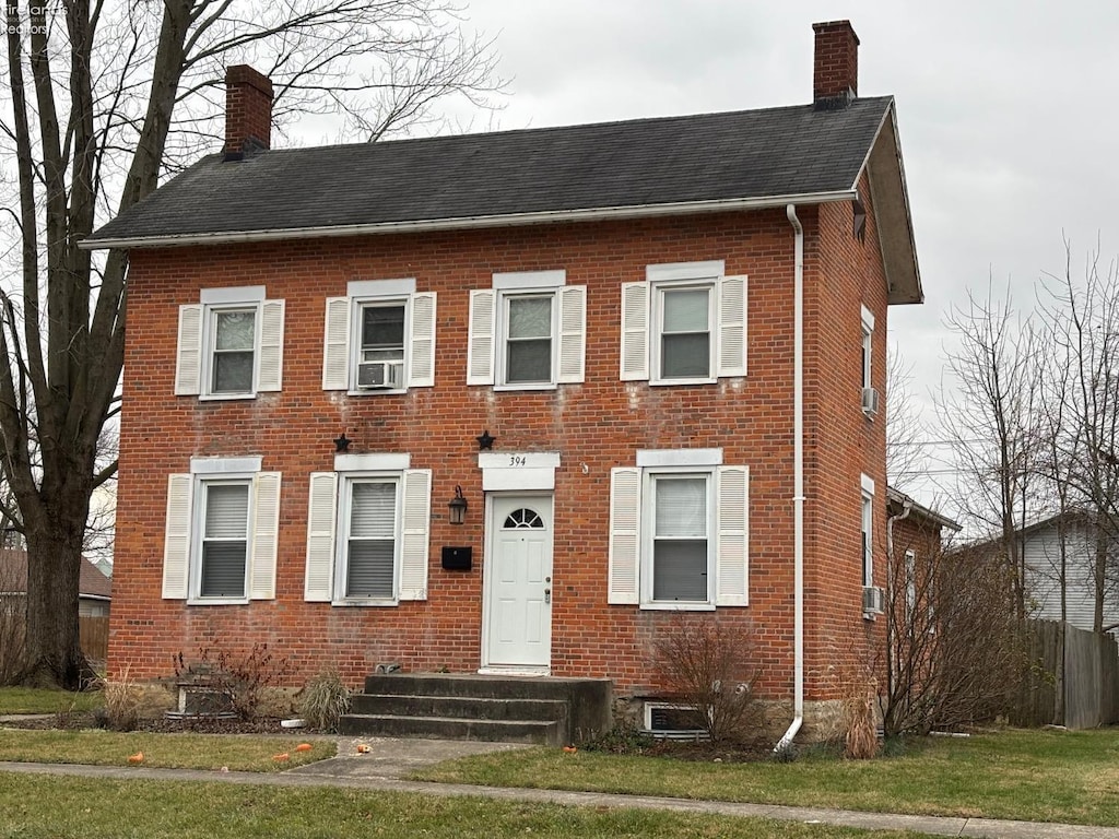 view of front of home featuring a front lawn and cooling unit