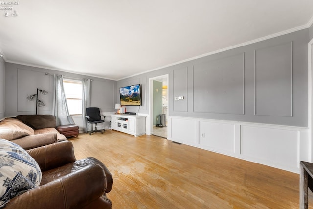 living room with light hardwood / wood-style floors and ornamental molding