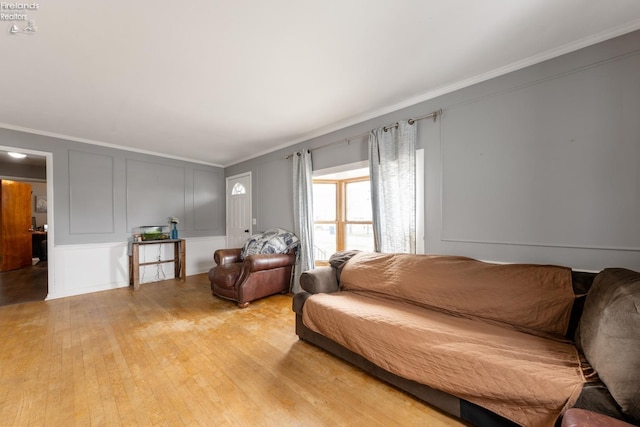 living room with light hardwood / wood-style floors and ornamental molding