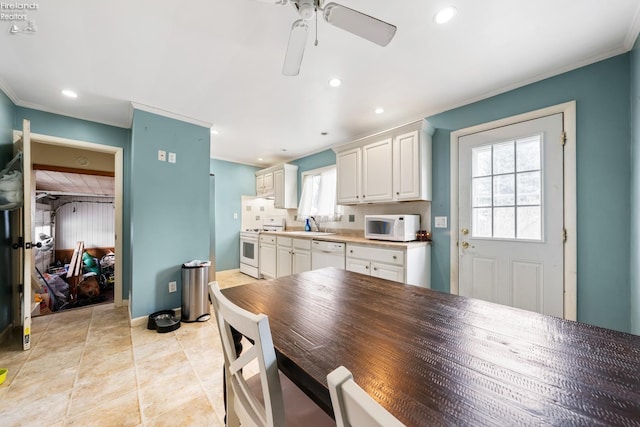 kitchen featuring white appliances, crown molding, sink, ceiling fan, and white cabinetry