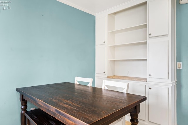 dining room featuring built in shelves and ornamental molding