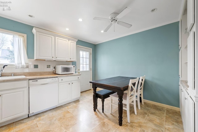 kitchen with backsplash, white appliances, ceiling fan, sink, and white cabinets