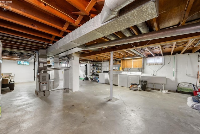 basement with separate washer and dryer, heating unit, and sink