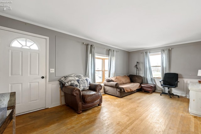 living room with light hardwood / wood-style flooring and ornamental molding