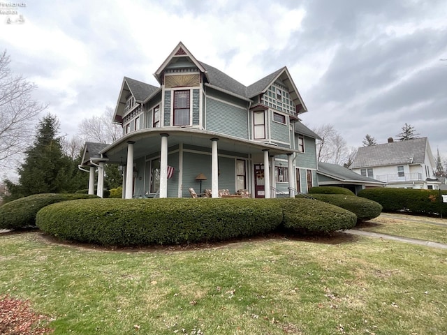 view of front of house with covered porch and a front yard