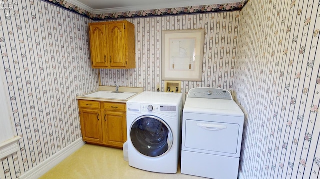 washroom with cabinets, independent washer and dryer, crown molding, and sink