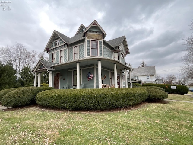 victorian home featuring a front lawn and a porch