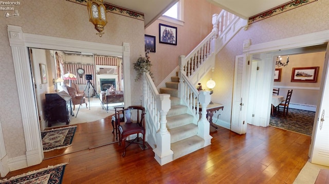 staircase with hardwood / wood-style flooring and a baseboard radiator