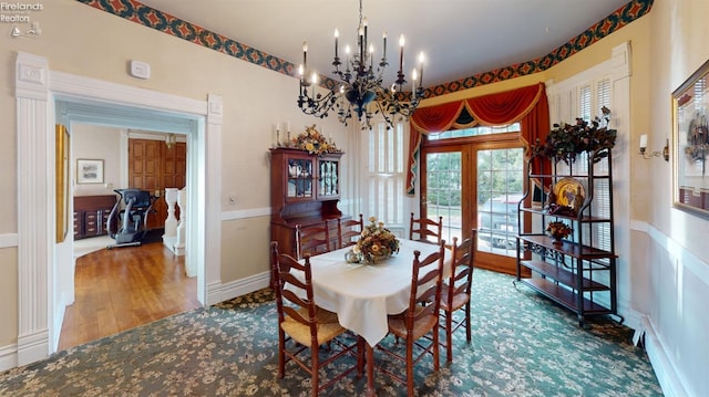 dining area with french doors, an inviting chandelier, and hardwood / wood-style floors