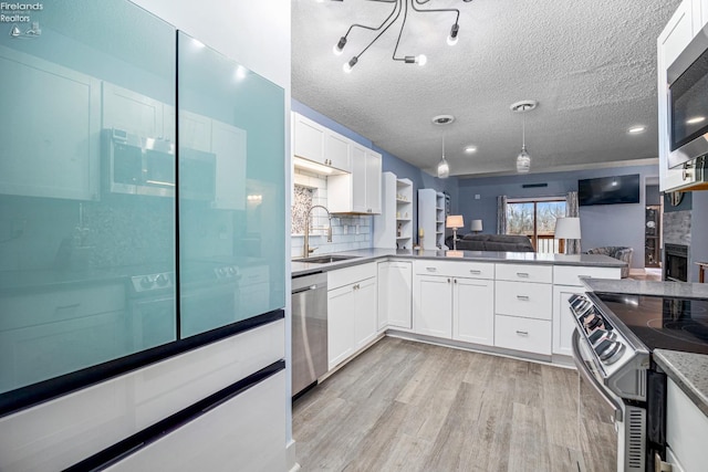 kitchen with white cabinets, sink, decorative backsplash, a textured ceiling, and stainless steel appliances