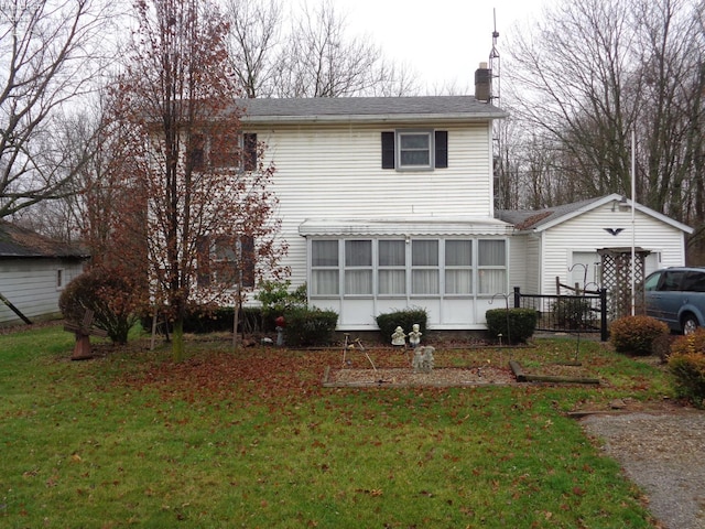 back of house featuring a yard and a sunroom