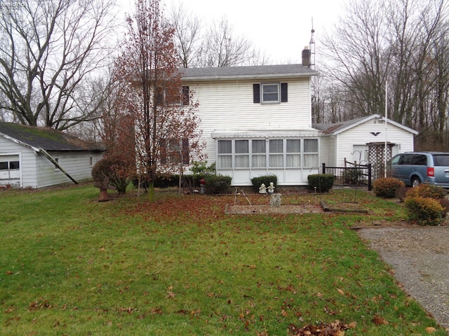 back of house with a sunroom and a yard