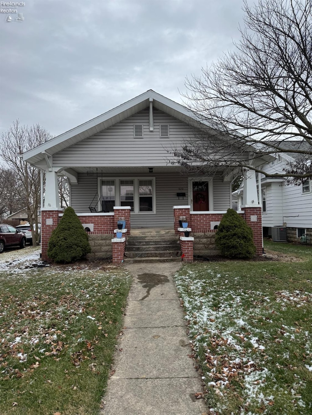 bungalow-style house with a porch and a front lawn