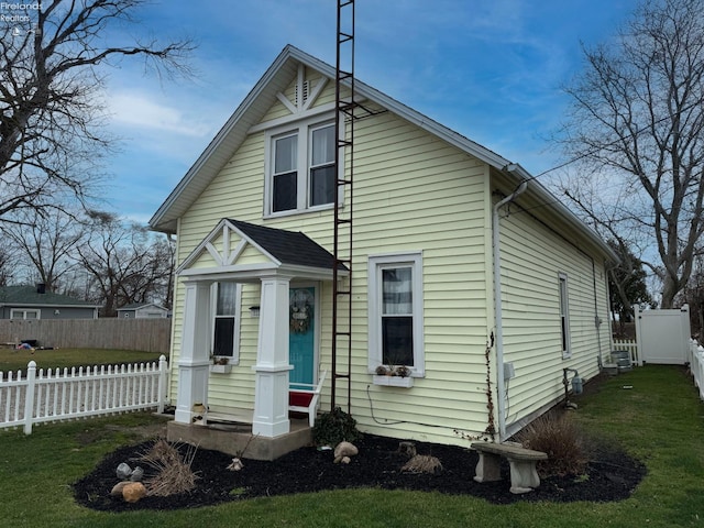 view of front of home with central AC and a front yard