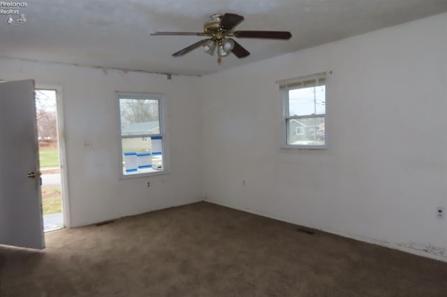 carpeted spare room with ceiling fan