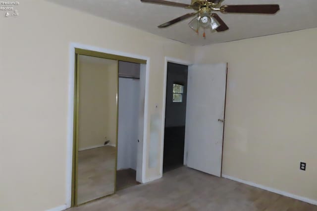 unfurnished bedroom featuring ceiling fan and a closet