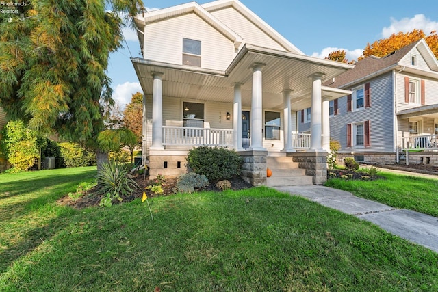 view of front of home with covered porch and a front lawn