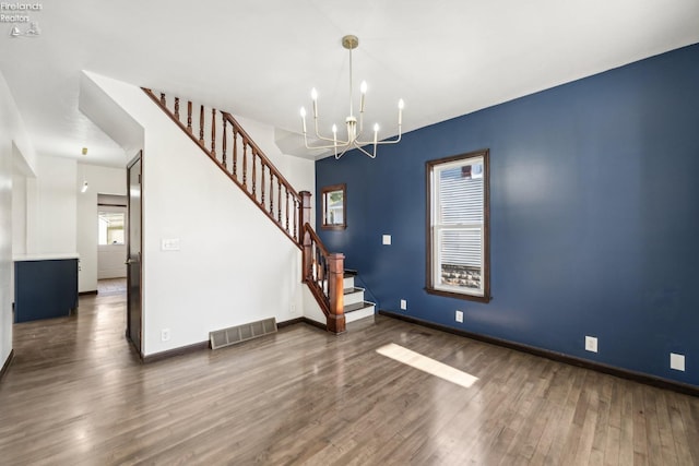 foyer entrance with dark hardwood / wood-style flooring and an inviting chandelier