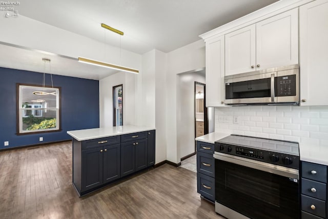 kitchen with decorative backsplash, stove, dark wood-type flooring, pendant lighting, and white cabinetry