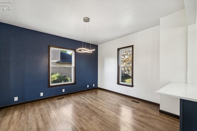 unfurnished dining area featuring dark hardwood / wood-style floors and a chandelier