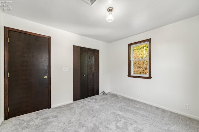 unfurnished bedroom with light carpet and a closet