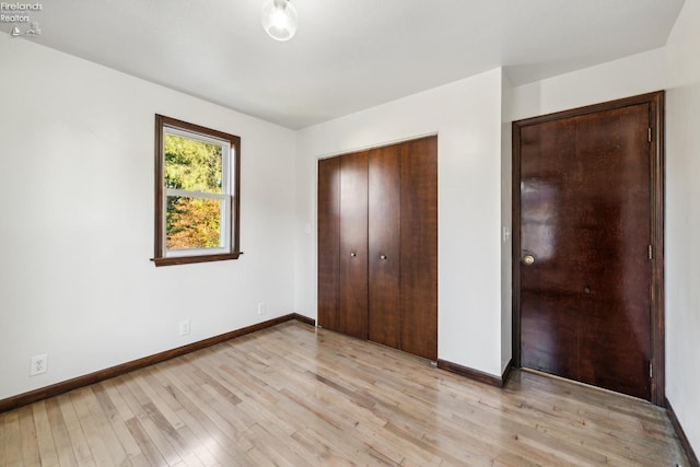 unfurnished bedroom featuring light wood-type flooring and a closet