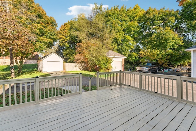 wooden terrace featuring a garage, a storage unit, a lawn, and a grill