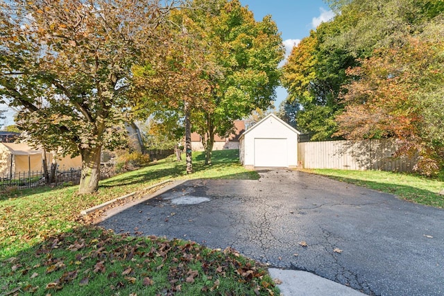 view of yard featuring a garage and an outbuilding