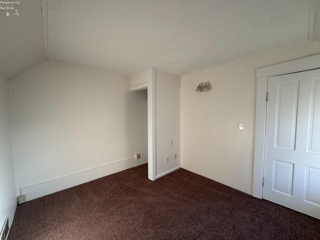 carpeted spare room with lofted ceiling