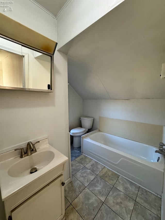 bathroom featuring a bathtub, vanity, vaulted ceiling, and toilet