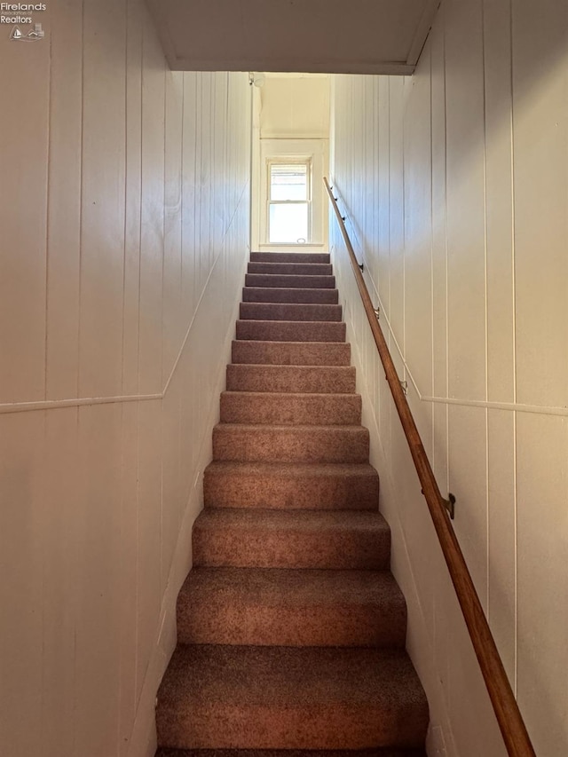 staircase with wood walls