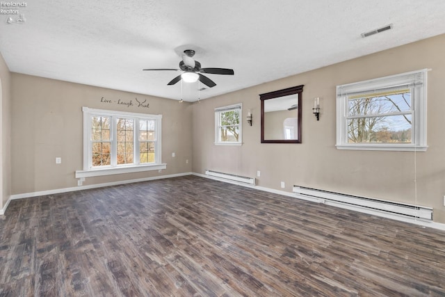 spare room featuring a textured ceiling, ceiling fan, dark hardwood / wood-style floors, and a baseboard heating unit