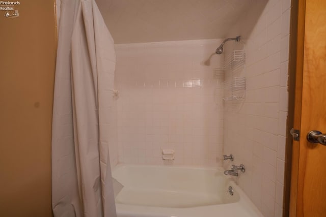 bathroom with shower / bath combo with shower curtain