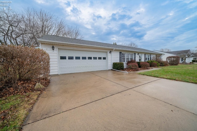 ranch-style house with a garage and a front lawn