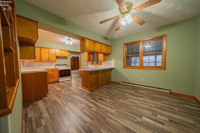 kitchen featuring kitchen peninsula, baseboard heating, ceiling fan, wood-type flooring, and electric range