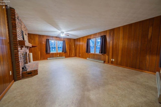 unfurnished living room with a fireplace, a baseboard radiator, ceiling fan, and wood walls