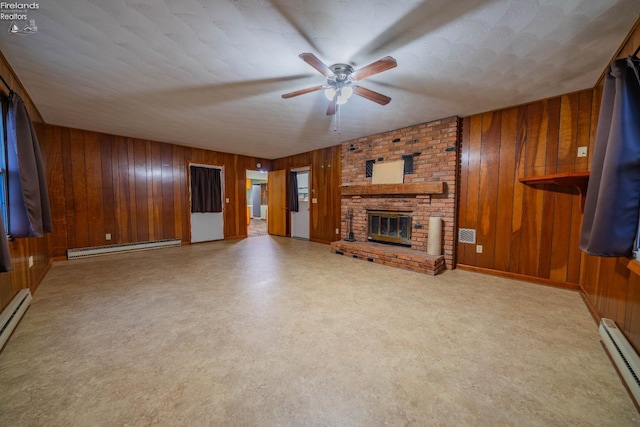 unfurnished living room featuring a fireplace, a baseboard radiator, ceiling fan, and wood walls