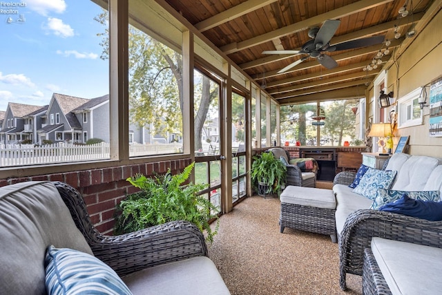 sunroom / solarium with vaulted ceiling with beams, ceiling fan, plenty of natural light, and wooden ceiling