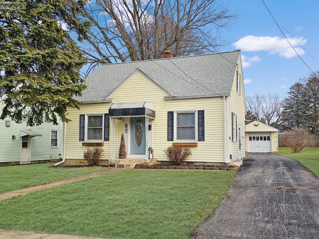 bungalow-style home with a garage, an outbuilding, and a front lawn