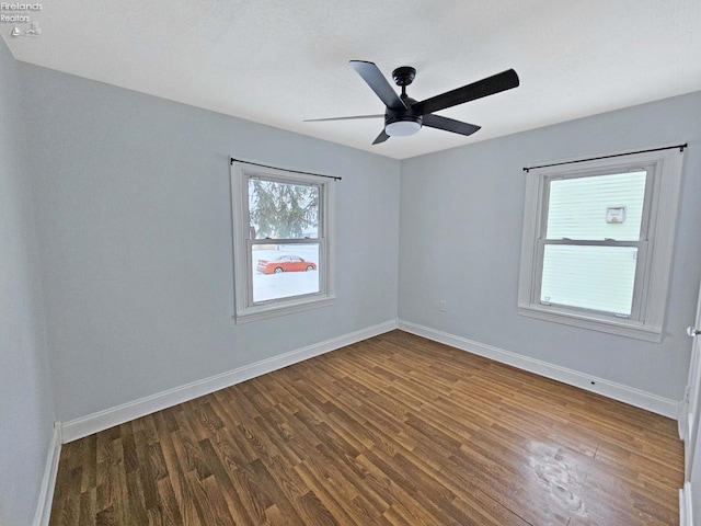 spare room with ceiling fan and dark hardwood / wood-style flooring