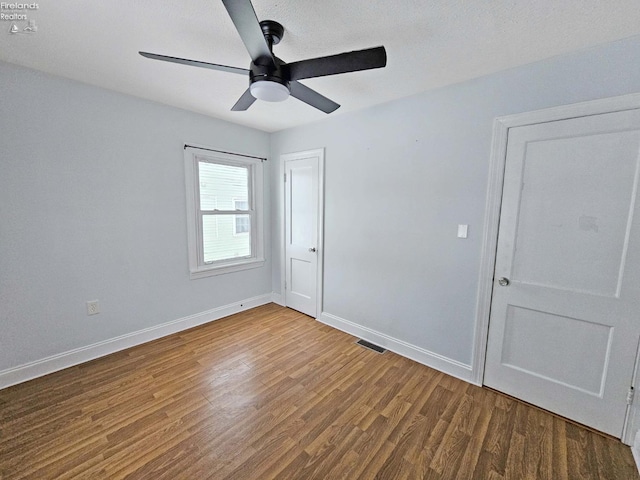 empty room featuring ceiling fan and hardwood / wood-style floors