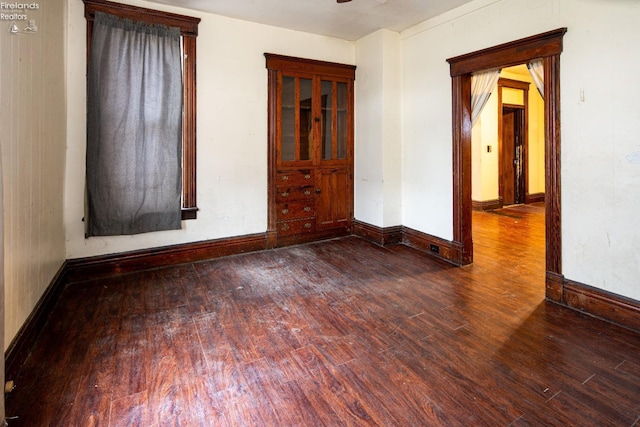 unfurnished room featuring dark wood-type flooring