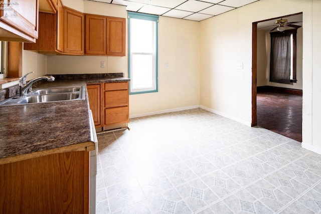 kitchen with a paneled ceiling, ceiling fan, and sink