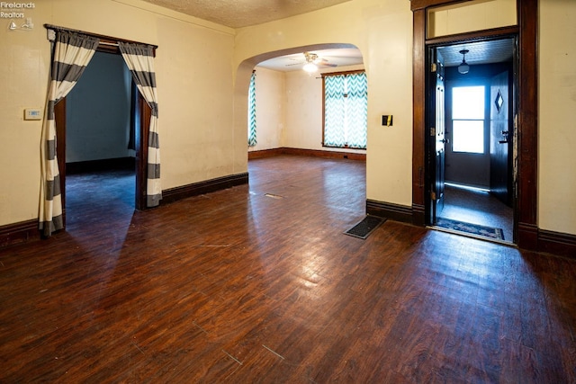 spare room with a textured ceiling, dark hardwood / wood-style floors, and ceiling fan