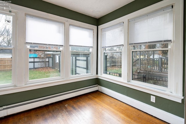 unfurnished sunroom featuring a baseboard heating unit